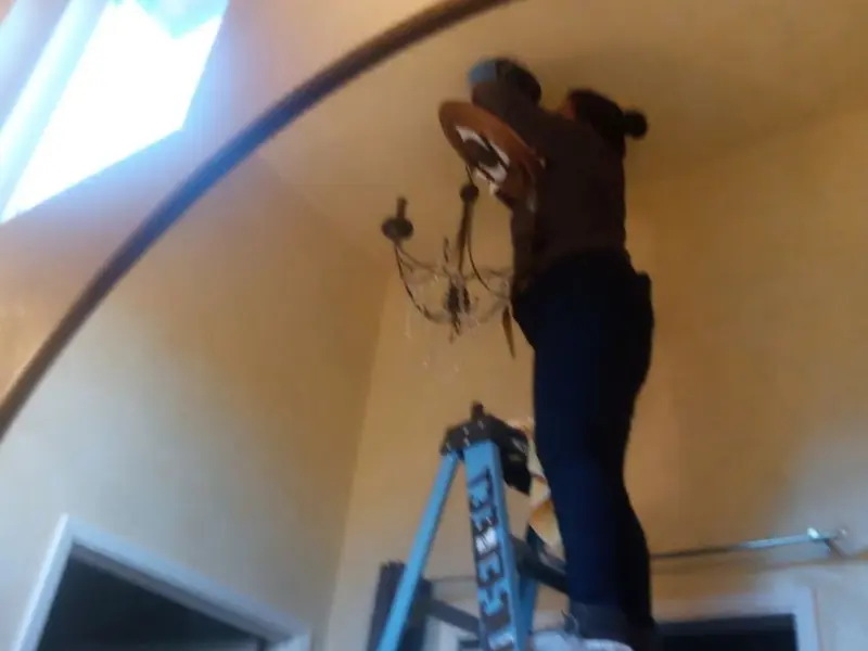Electrician installing a chandelier in a Galen residence